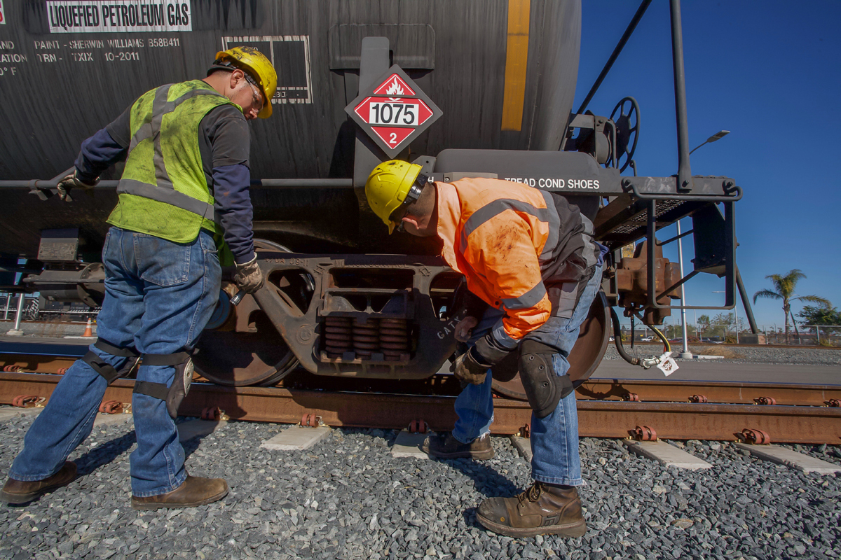 Two workers performing a tank car inspection
